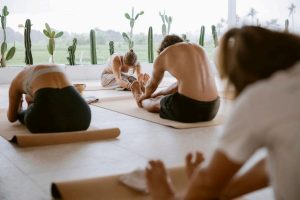 A yoga session performed by several adults indoors