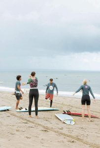 Group of people on the beach, preparing to surf