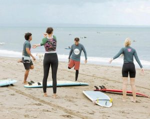 A group of people on the beach, preparing surf