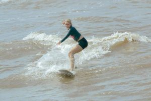 A woman is surfing the waves