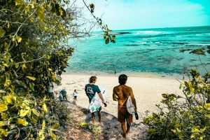 Two men walked toward the beach carrying surfboards
