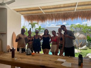 A group of seven adults smiling and posing for a group photo at the Bali Surf Camp Kavomaison