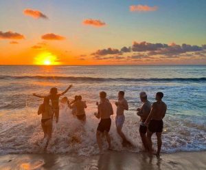 A group of people enjoying a sunset on a beach