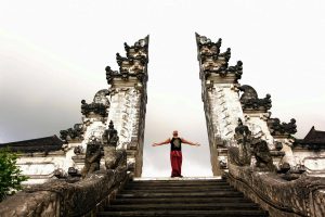 A man stands between the gates of Pura Penataran Agung Lempuyang, known as the Gateway to Heaven in Bali