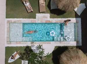 An aerial view of the Kavo Maison pool area, with several people sunbathing and swimming