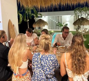 A group of friends enjoying dinner together at Kavo Maison Surf & Yoga Camp
