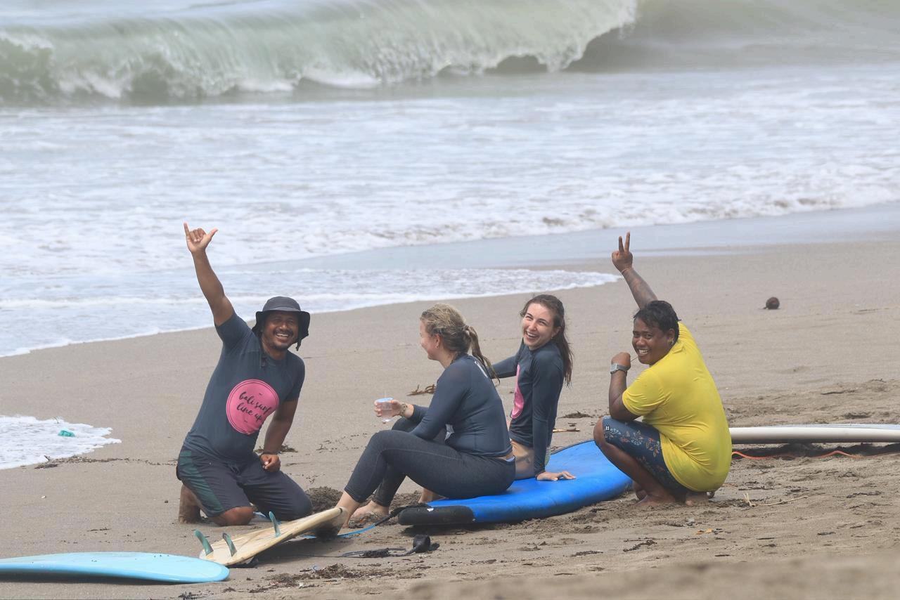A group of people taking a surfing lesson at a beach