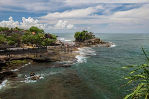 A view of Tanah Lot Temple, an iconic seaside temple in Bali that stands majestically atop a large rock formation on the beach