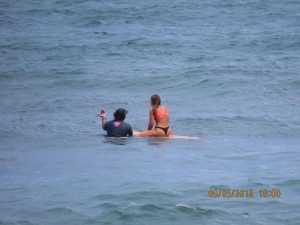 A surf instructor giving a lesson to a surfer in the water
