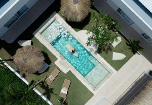 This aerial view shows the courtyard and elongated swimming pool of the Kavo Maison Surf & Yoga Camp located