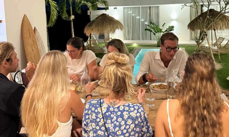 A group of friends enjoying dinner together at Kavo Maison Surf & Yoga Camp