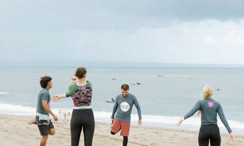 Group of people on the beach, preparing to surf