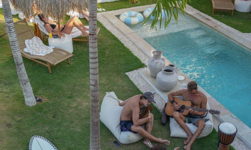 guests relaxing by the pool at Kavo Maison Surf & Yoga Camp